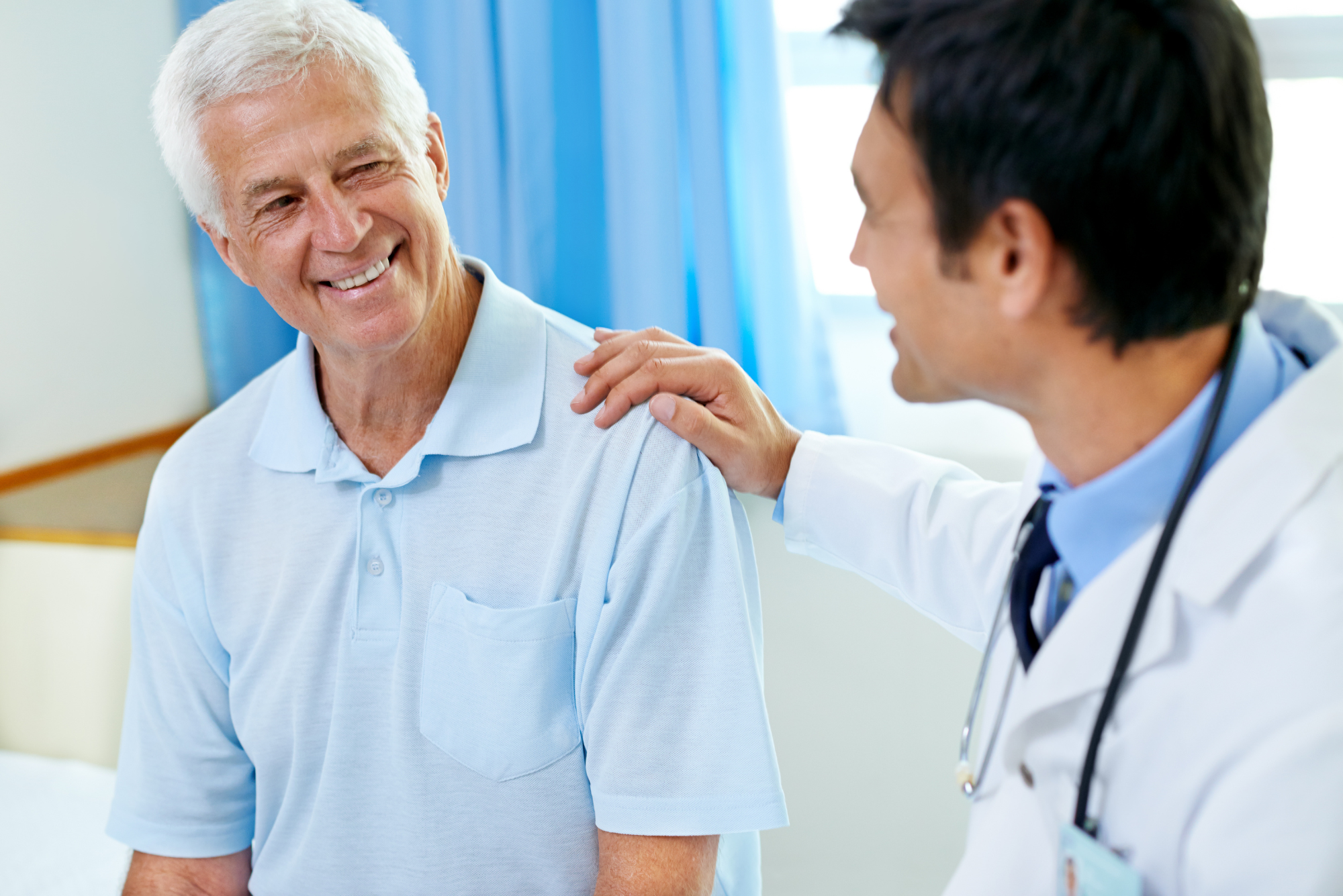 Smiling elderly man in consultation with a doctor, representing choosing the best concierge doctor near you.