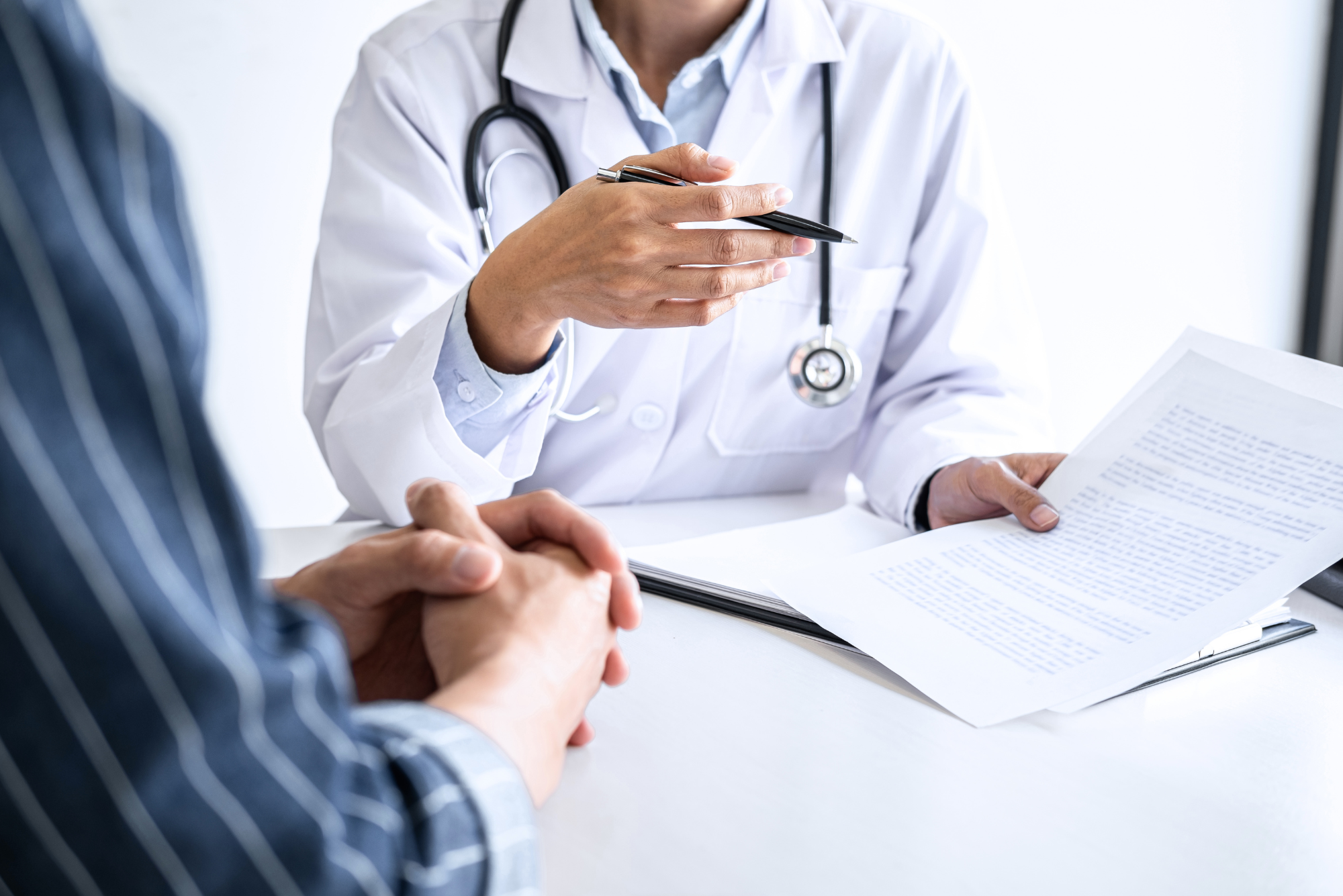 Doctor in a white coat discussing executive physical exam results with a patient.